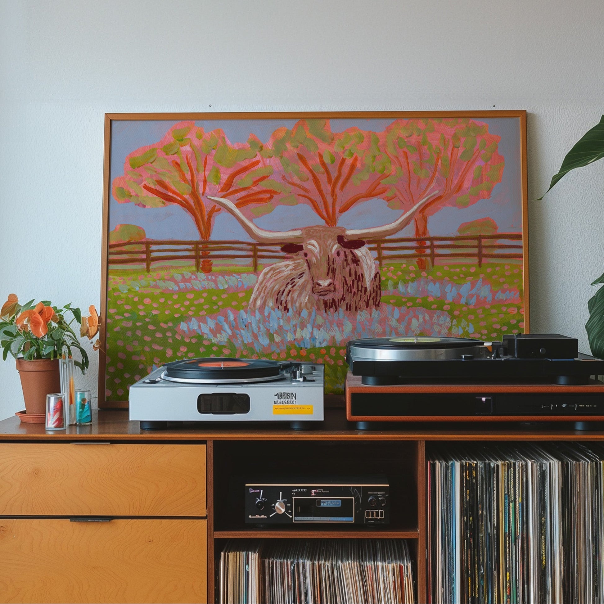 Wooden cabinet with vinyl records, record player, and artwork of a cow and trees.