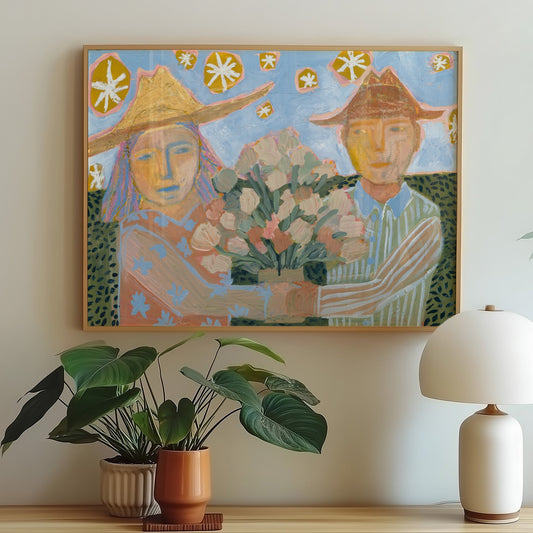 Framed artwork of two people with a bouquet on a wooden console table with plants and a lamp.